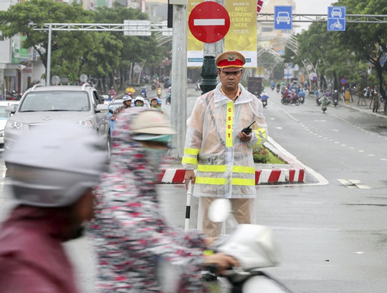 Cảnh sát phân luồng xe APEC dưới mưa