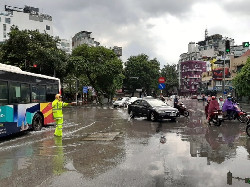 Cảnh sát giao thông dầm mình trong mưa lớn, đường ngập để phân luồng chống ùn tắc