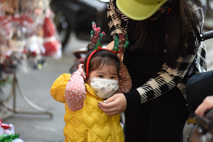 Số ca Covid-19 không ngừng tăng, thiếu nữ Hà Nội vẫn thích thú check-in ở phố Hàng Mã rực màu Giáng sinh