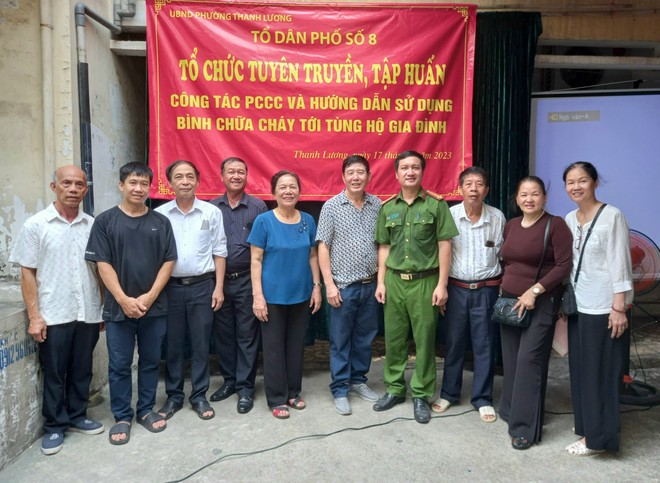 Bà Nguyễn Thị Đính (áo xanh, đứng giữa) cùng CAP và cán bộ cơ sở khu dân cư, tổ dân phố tại buổi tuyên truyền tập huấn công tác PCCC ảnh 1