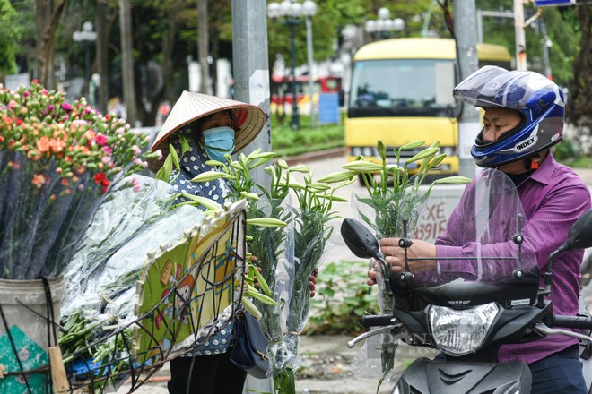 Dù vội đến mấy nhiều người vẫn sẵn lòng dừng chân ghé lại những gánh hoa ven đường để chọn mua vài cành loa kèn đầu mùa thật đẹp