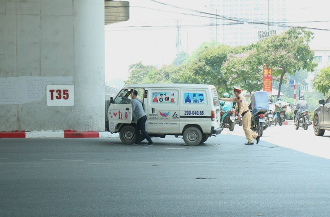 Cán bộ Đội CSGT đường bộ số 14 giúp đỡ một trường hợp ô tô bị hỏng trên đường Giải Phóng - Ngọc Hồi.